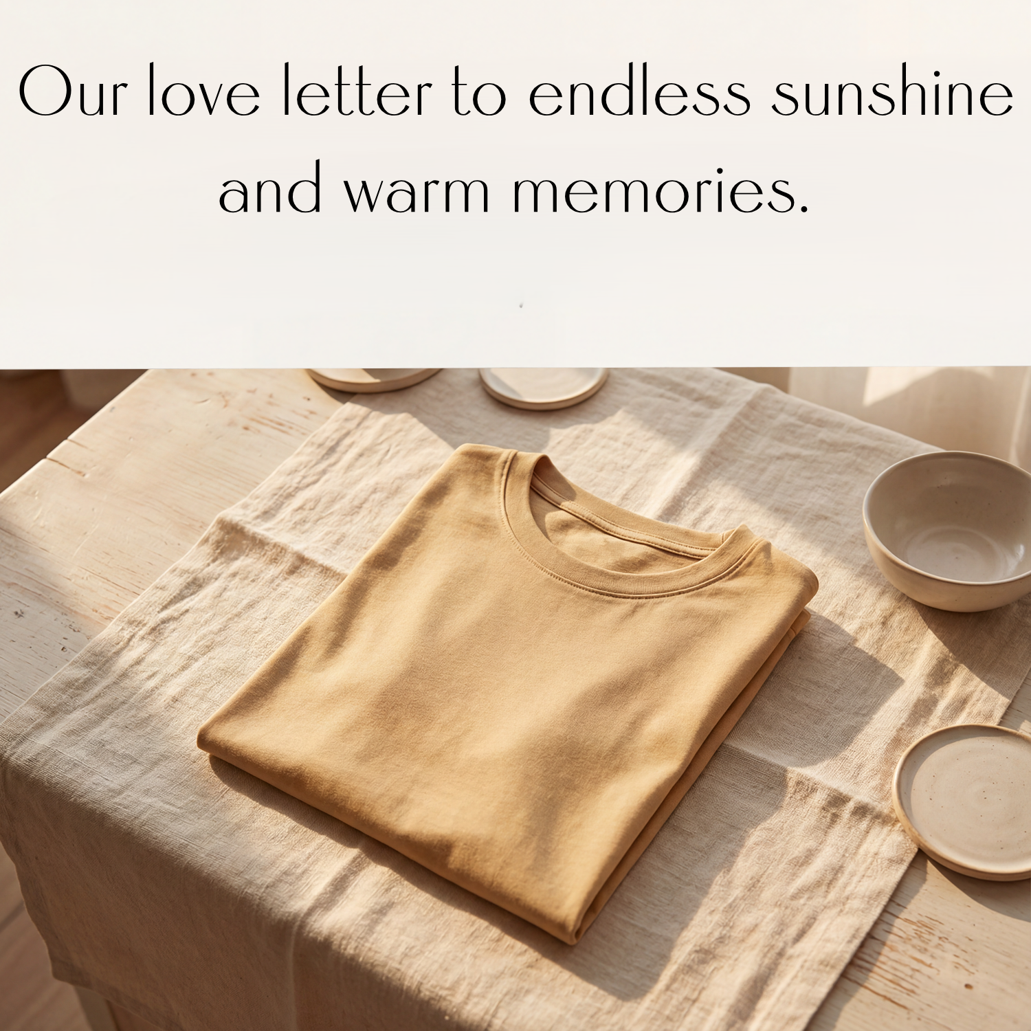 Minimal summer apparel flat lay featuring a folded neutral t-shirt on a linen table with ceramic accents and warm sunlight.